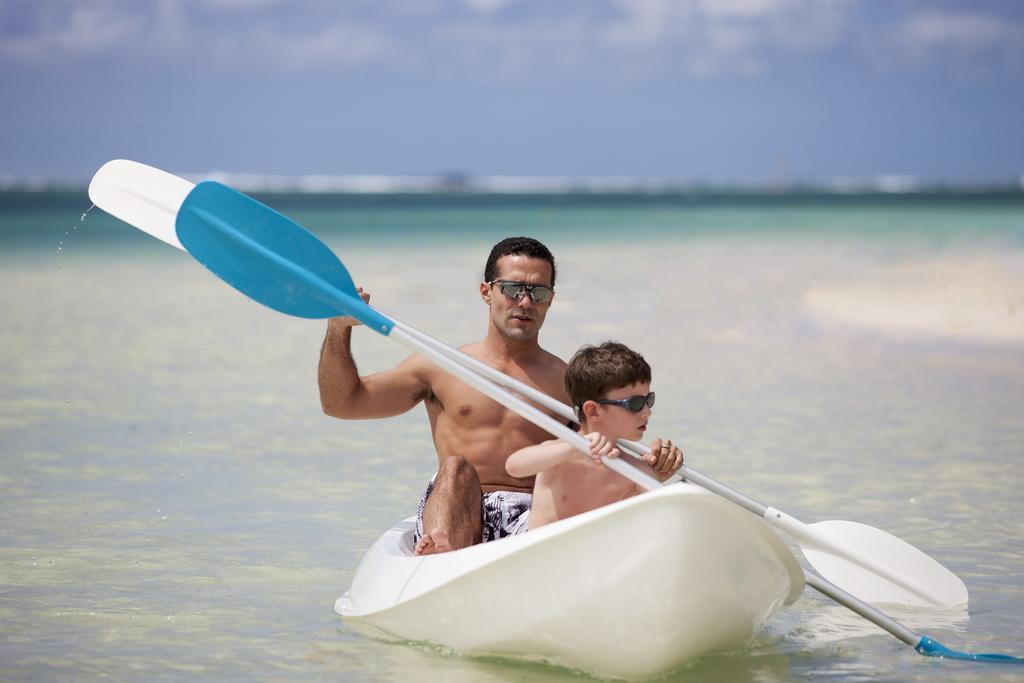 The Residence Mauritius Belle Mare Esterno foto A father and son in a kayak